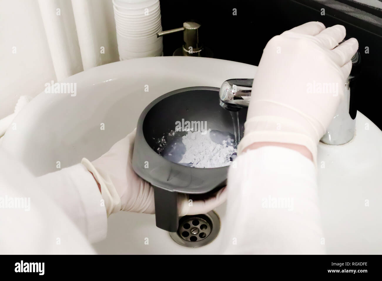 cosmetologist in white glove in beauty salon pouring water in caviar peel off mask for facial skin care in plastic bowl preparation for skin treatment stock photo alamy alamy