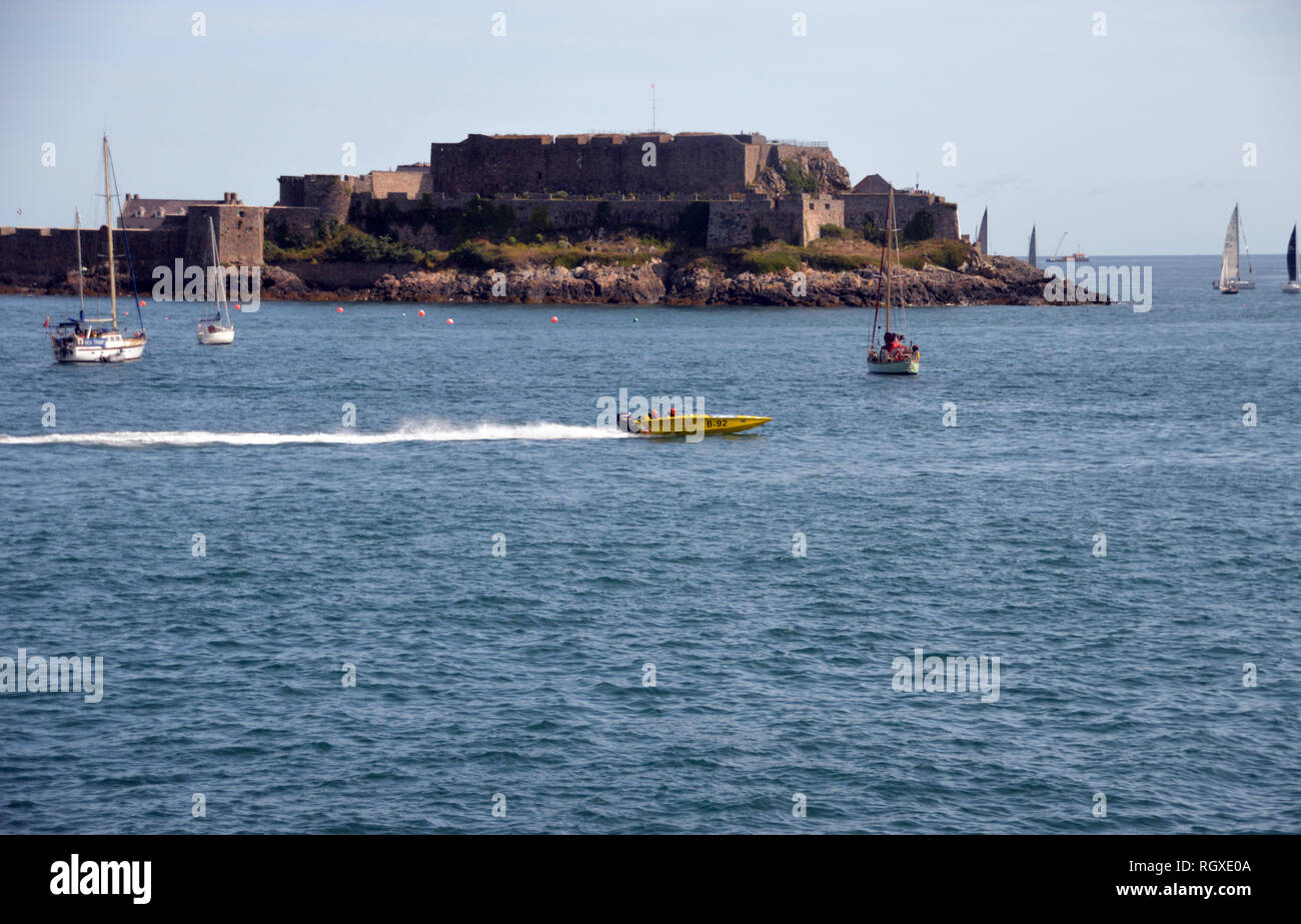 A Yellow Power Boat Racing in Havelet Bay in front of Castle Cornet, St Peter Port, Guernsey, Channel Islands.UK. Stock Photo