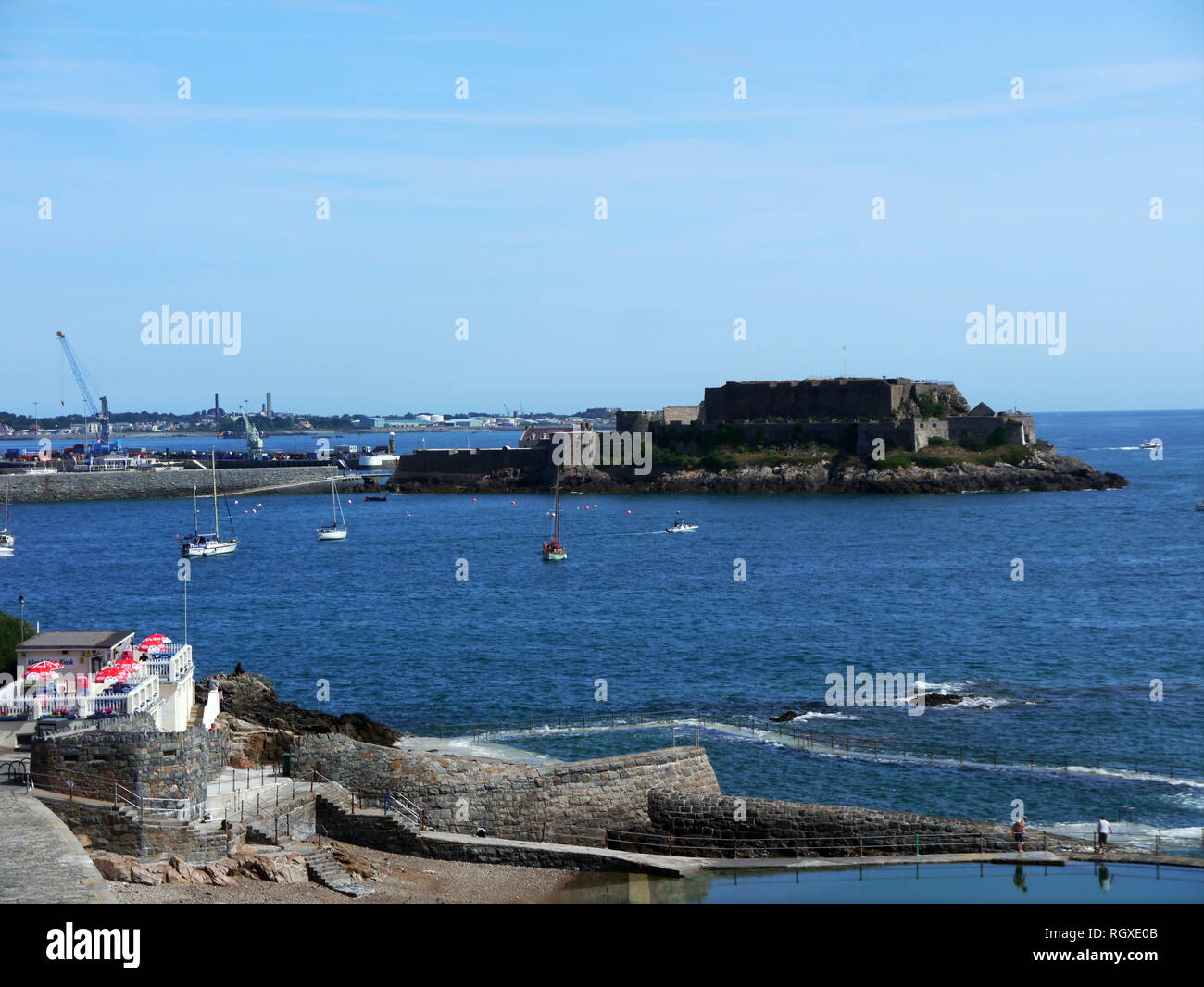 Two Men Looking over Havelet Bay to Castle Cornet in from the Outdoor Swimming Pool in St Peter Port , Guernsey, Channel Islands.UK. Stock Photo
