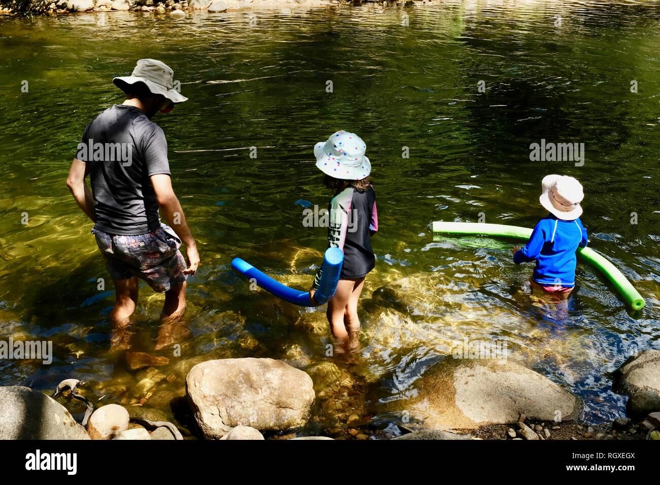 A father and children prepare to swim in a river, Finch Hatton, Queensland 4756, Australia Stock Photo