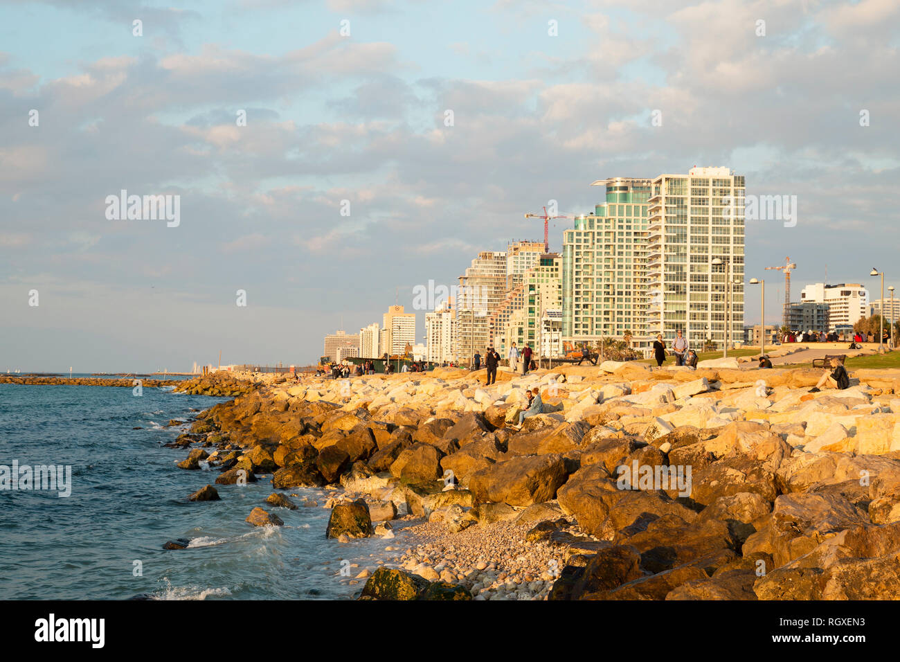 Tel Aviv - Yafo, Israel - December 23, 2018: A beautiful golden sunset scene of Tel Aviv seacoast walk, seafront rocks and the modern architecture at  Stock Photo
