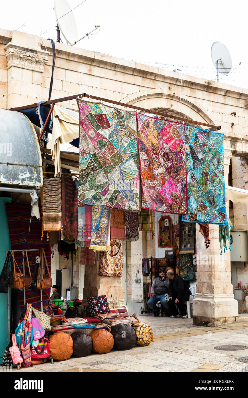 Old City, Jerusalem, Israel - December 24th 2018: A textile shop and vendors having a chat at front of in Christian Quarter, Old City, Jerusalem, Isra Stock Photo