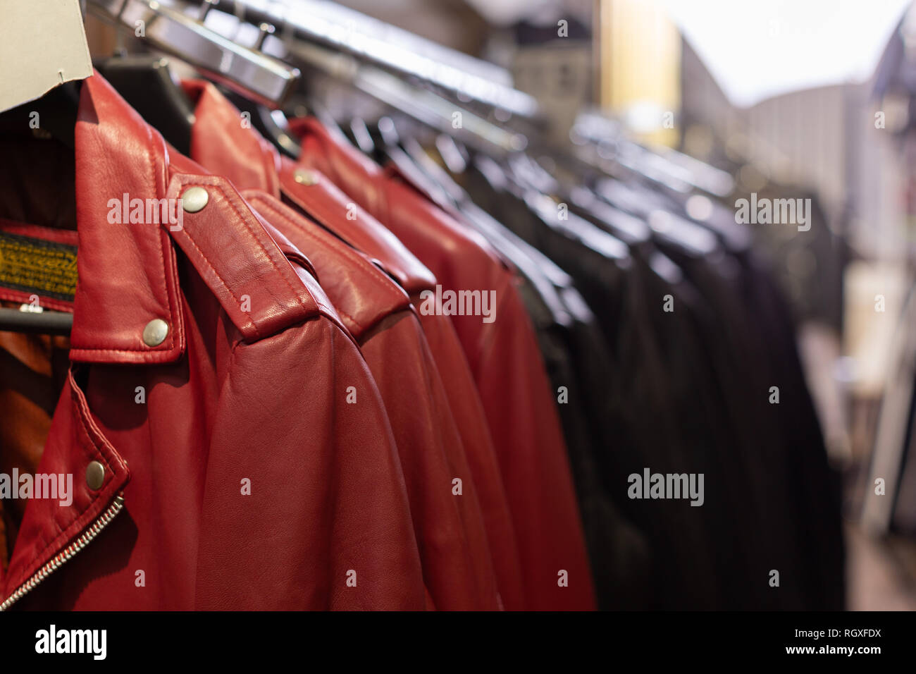Close up view of different colors jackets on racks in leather clothes store Stock Photo