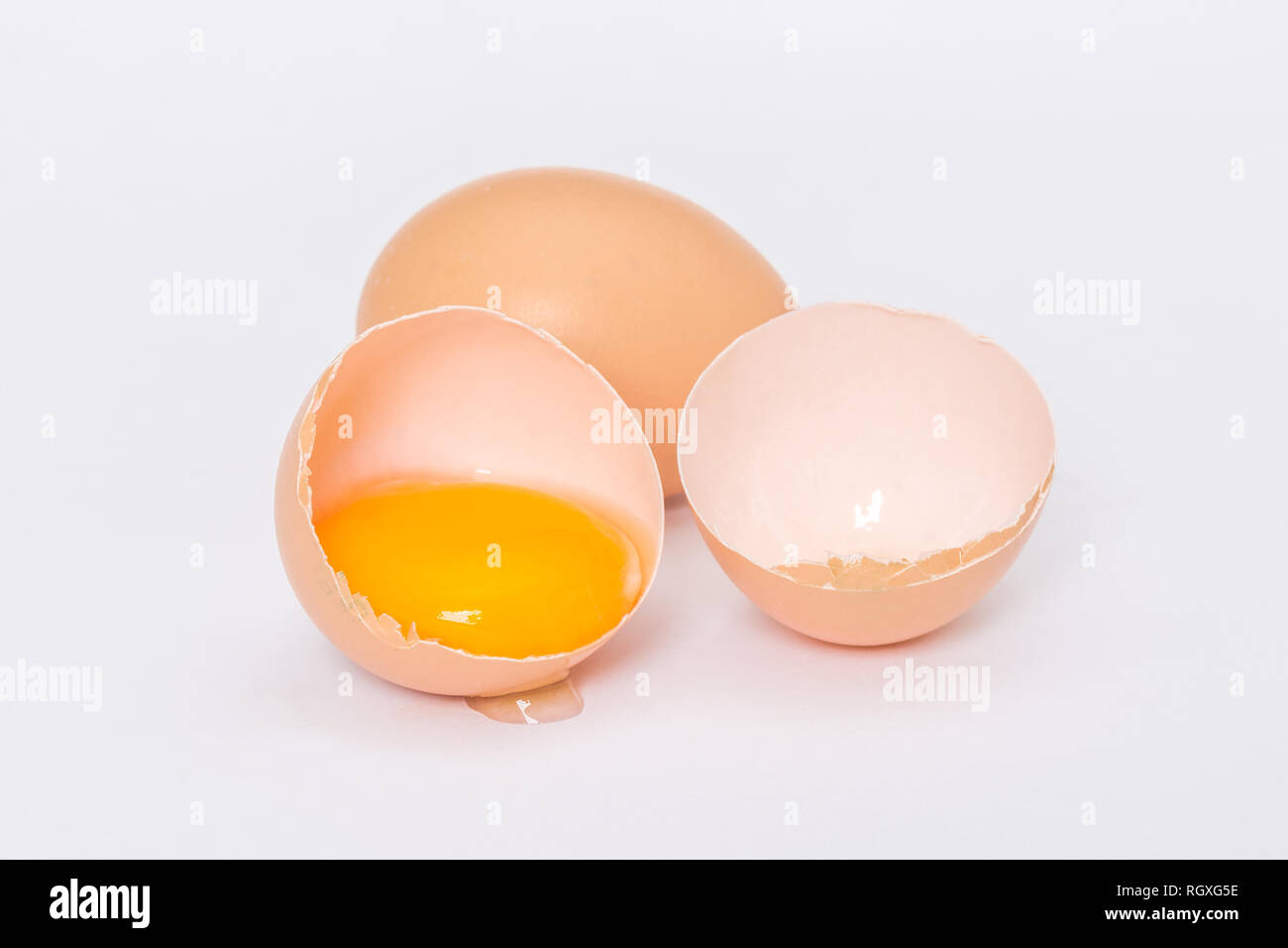 Broken egg on a white background Stock Photo - Alamy