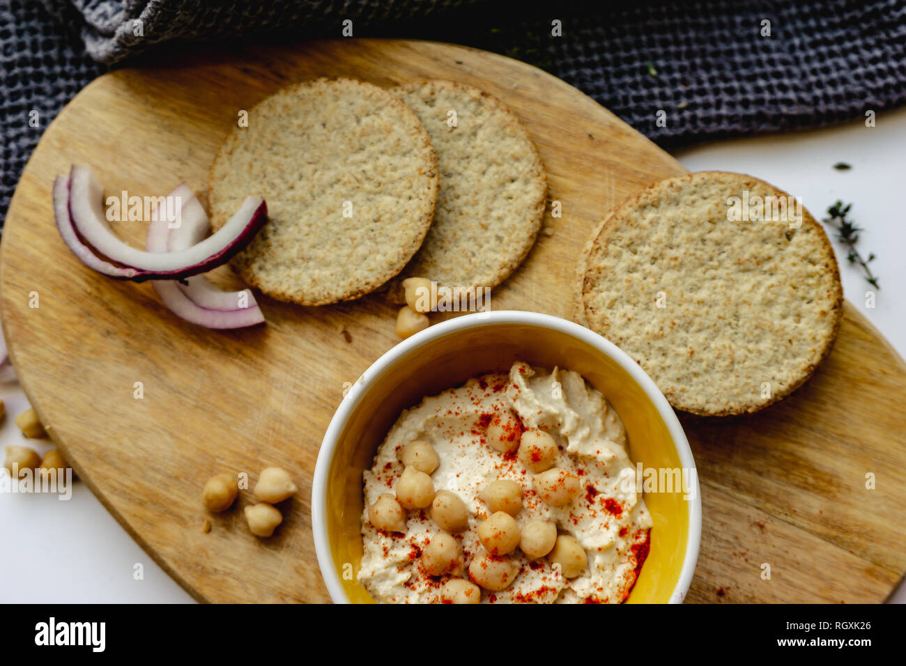 Scottish oatcakes with hummus presented with relevant additions on white background. Stock Photo