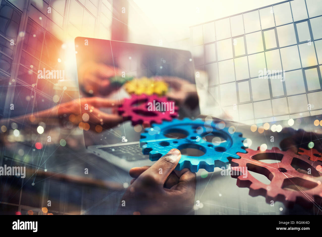 Business people with gears in hand that exit from a laptop. concept of remote cooperation and teamwork. Double exposure Stock Photo