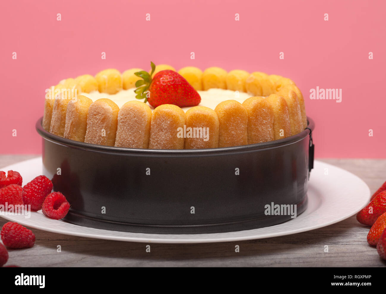 https://c8.alamy.com/comp/RGXPMP/diplomat-cake-or-charlotte-cake-with-strwaberries-and-lady-fingers-in-baking-pan-on-a-wooden-table-with-pink-background-RGXPMP.jpg