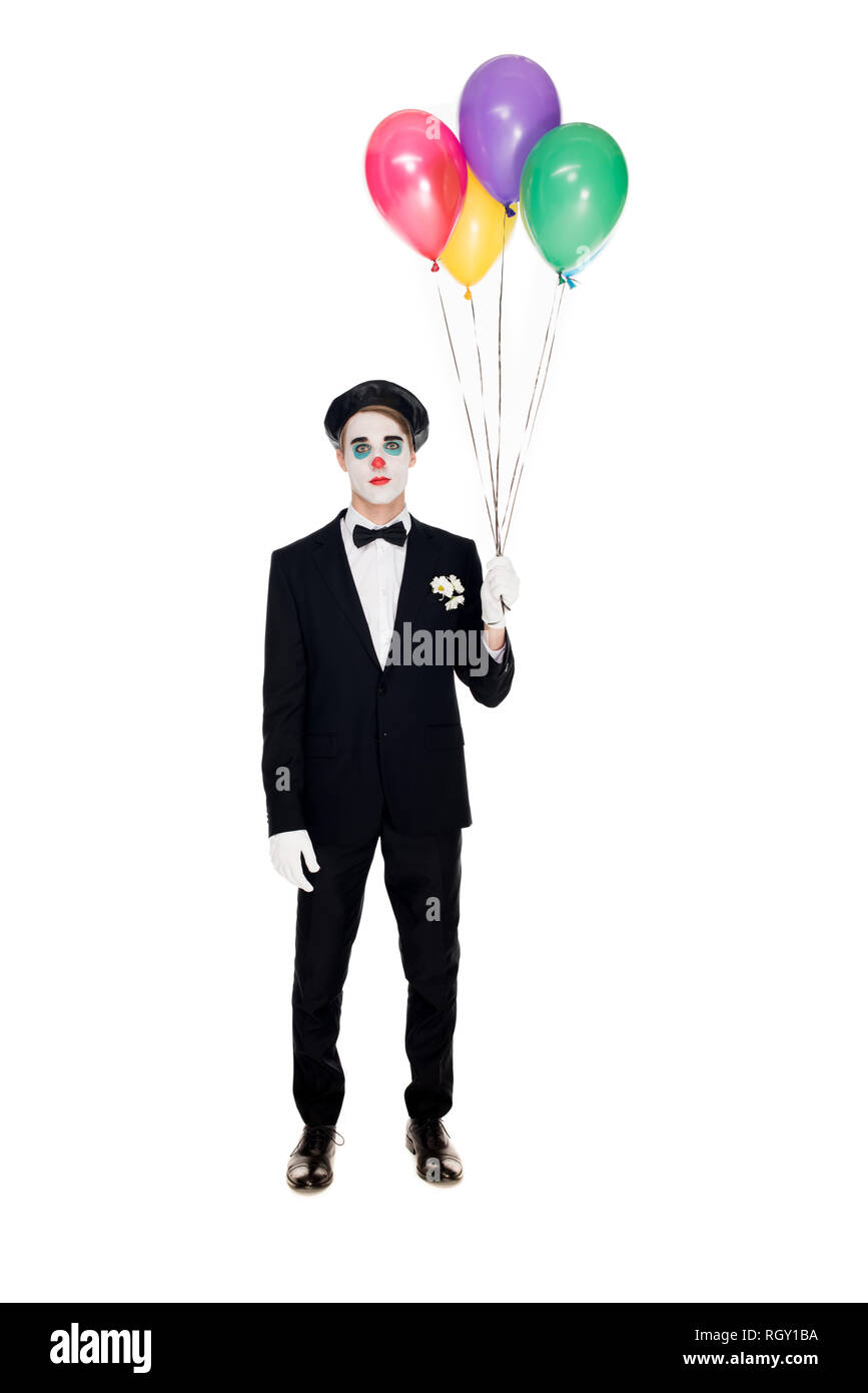 sad clown in suit and black beret holding helium balloons isolated on white Stock Photo