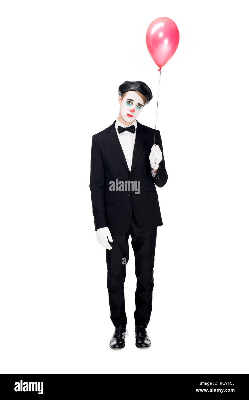 sad clown in suit and black beret holding balloon and standing isolated on white Stock Photo