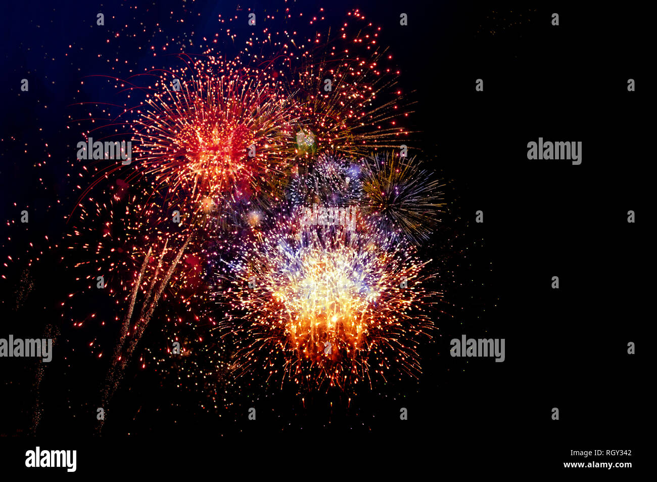 Red, orange, and yellow fireworks display on black background with room ...