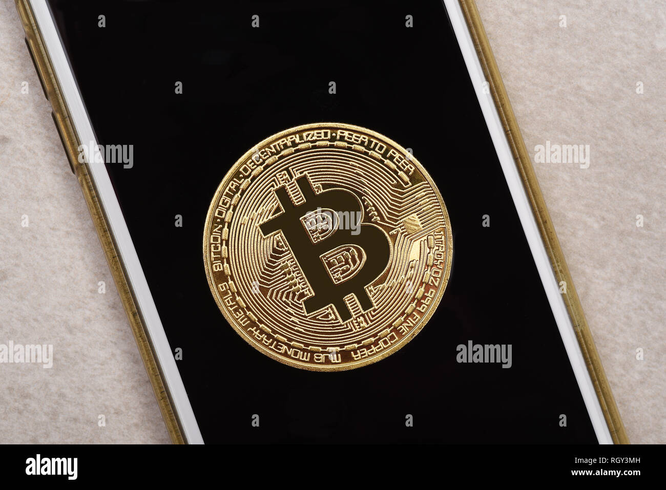 E-Conmmerce Concept: Closeup of a Bit Coin on top of a smart phone screen. Stock Photo