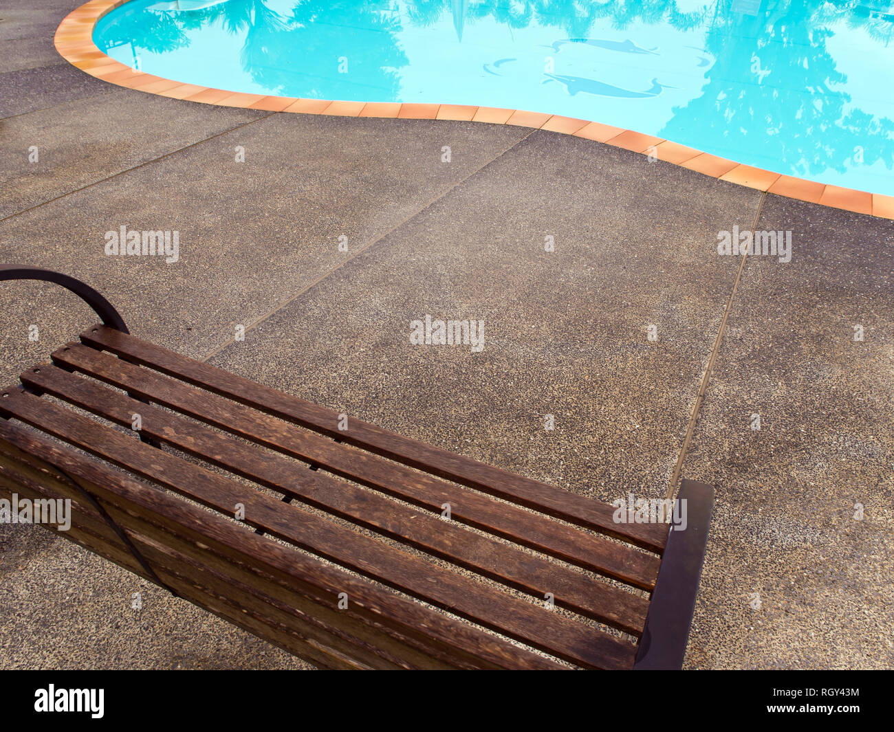 Wooden chairs on a concrete floor. Beside the pool Stock Photo Alamy