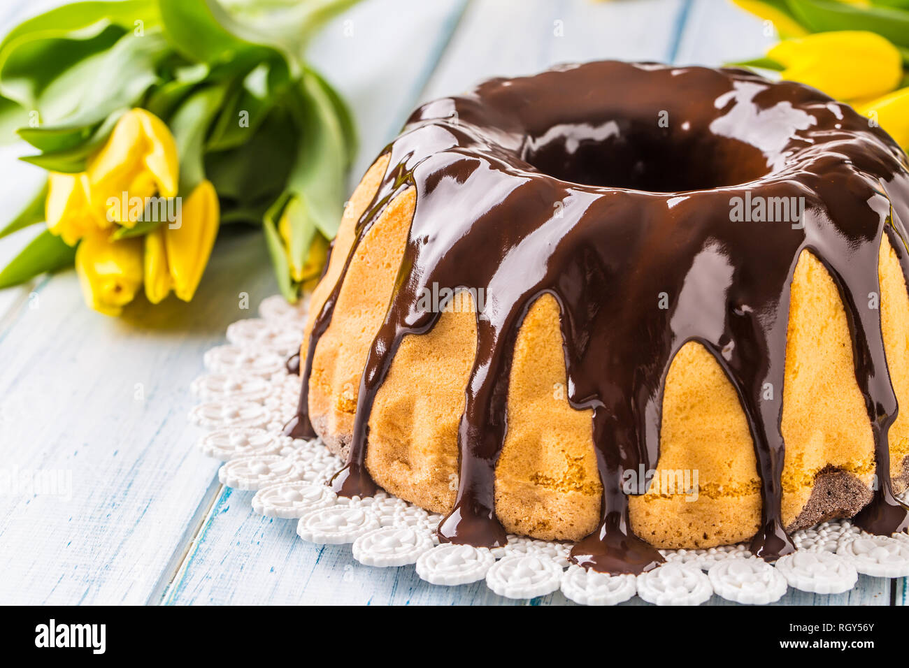 Delicious holiday slovak and czech cake babovka with chocolate glaze. Easter decorations - spring tulips and eggs. Stock Photo