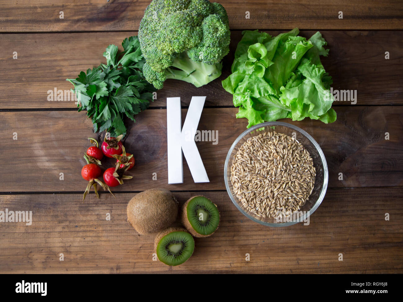 Foods highest in Vitamin K and letter K on a wooden board. Healthy