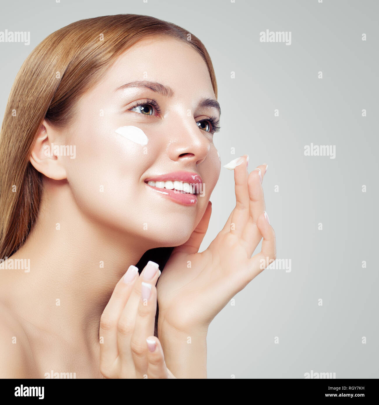 Face of a beautiful girl with perfect skin. Young woman applyng