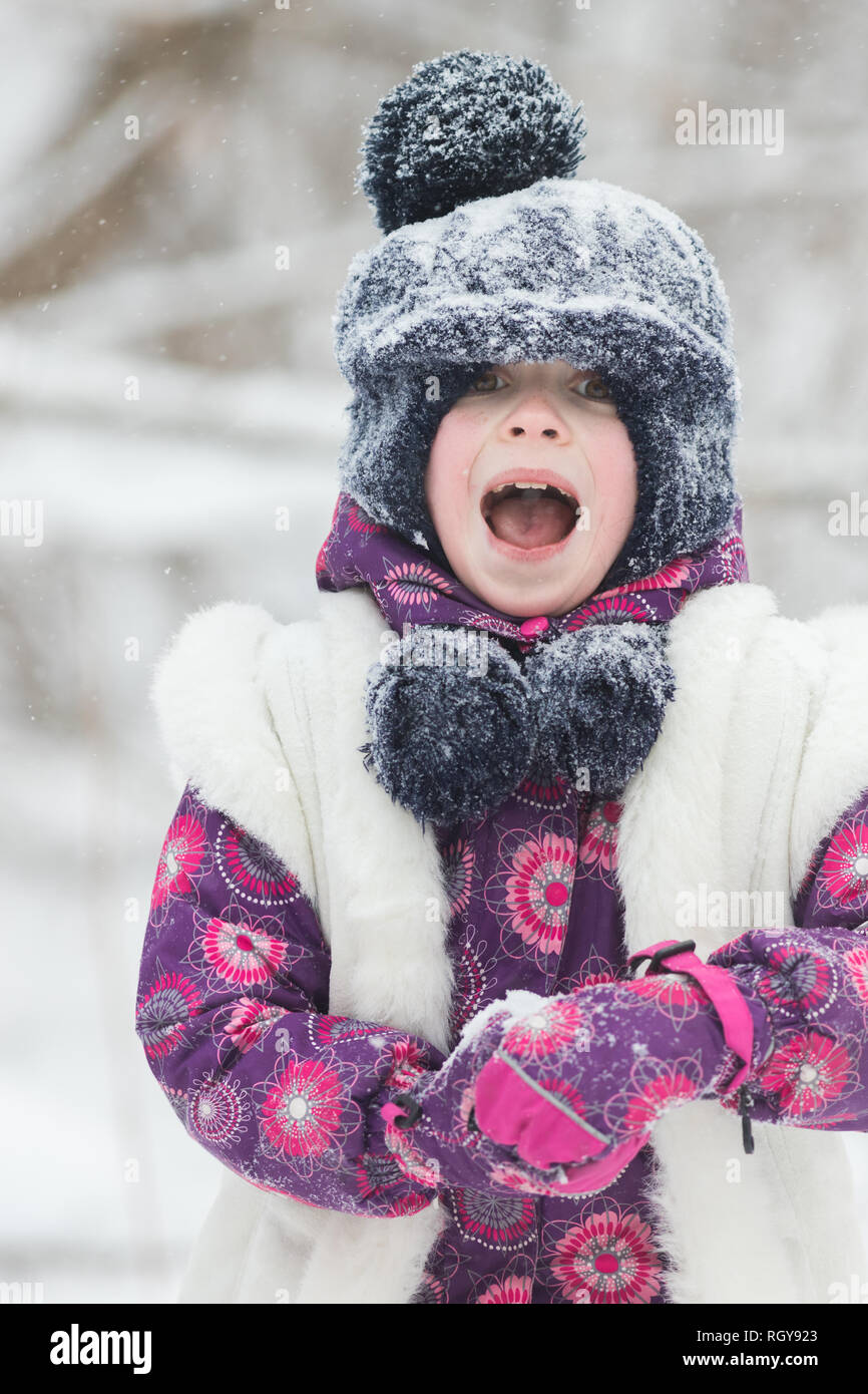 Excited little girl in pink jacket in winter forest. Portrait Stock