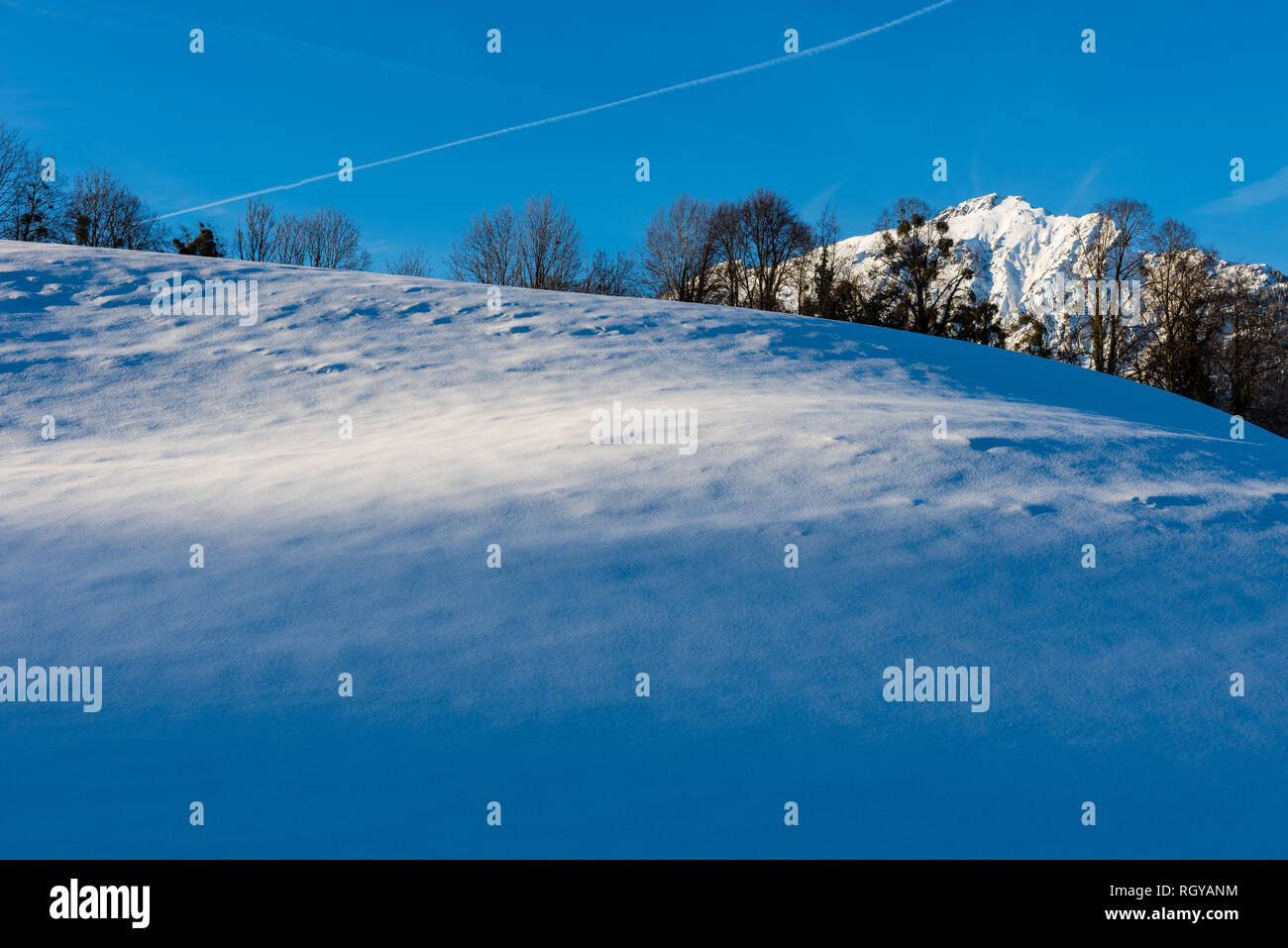 Last Sunrays on a Snowfield in Bayrisch Gmain, Bavaria, Germany Stock Photo