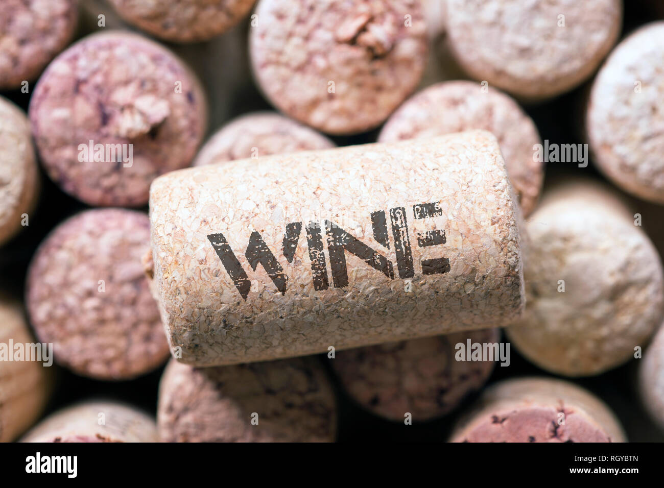 single wine cork with wine word print laying on the many corks background Stock Photo