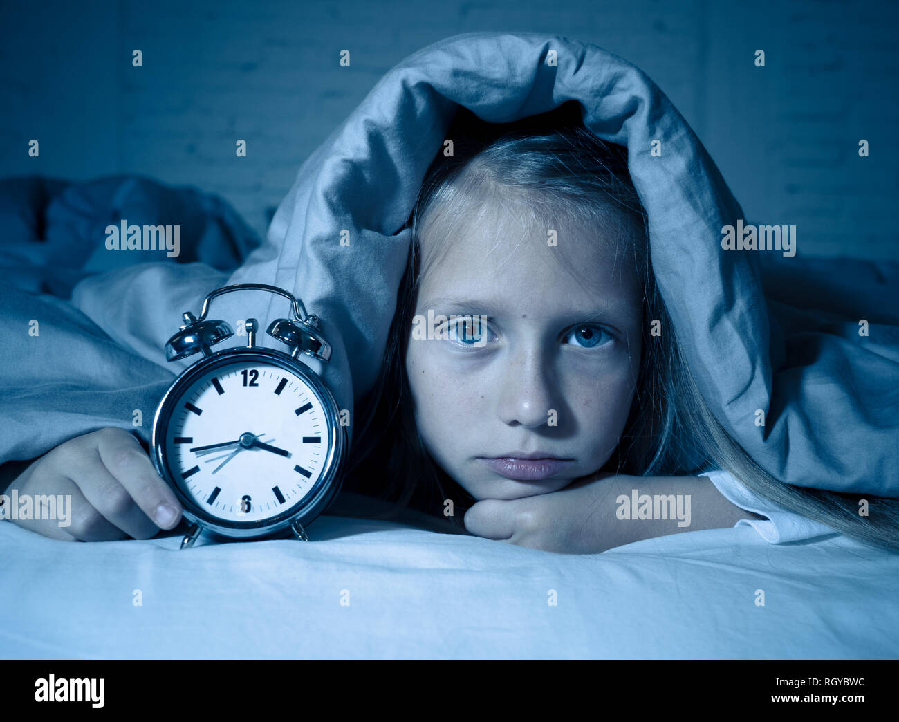 Cute sleepless little girl in bed awake in the middle of the night