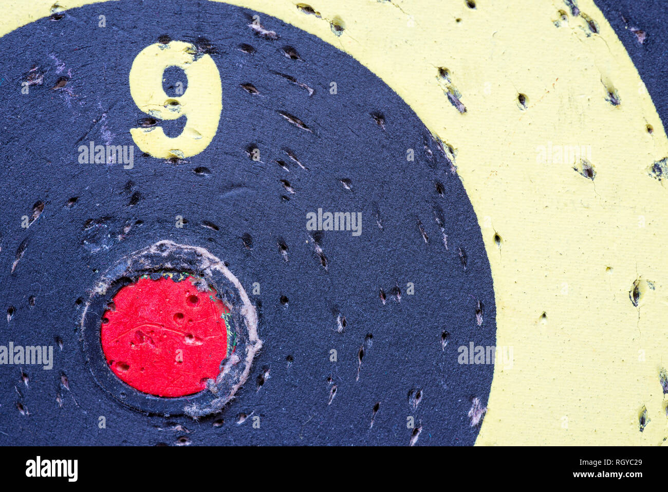 darts target closeup fragment with red center and many holes Stock Photo