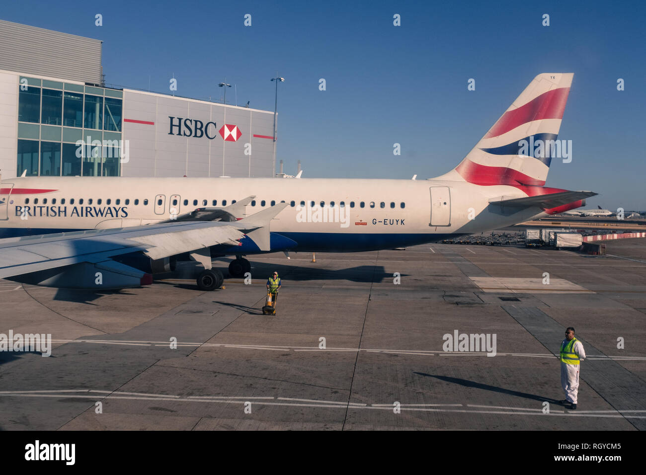 British Airways airplane on the tarmac outside an HSBC hanger on a sunny day Stock Photo