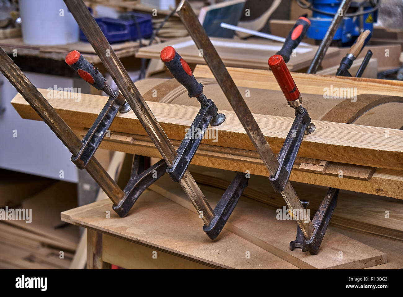 Production of curved MDF cabinet doors. Metal clamps tightening mdf  details. Wooden furniture manufacturing process Stock Photo - Alamy