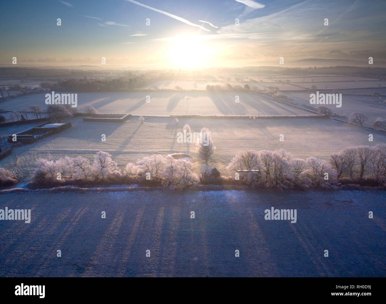 The sun rising over the frozen fields in rural East Sussex Stock Photo