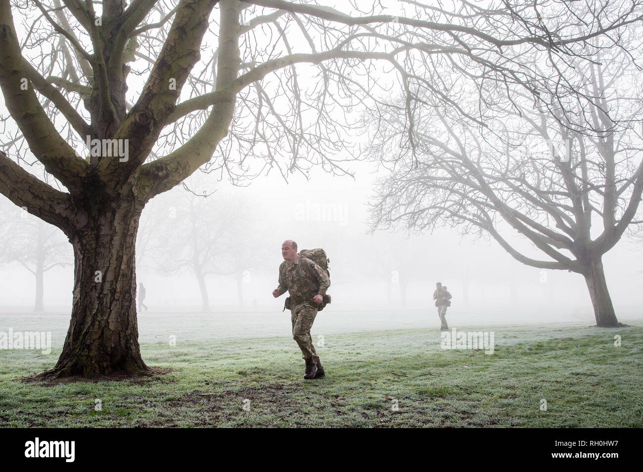 Windsor, UK. 31st January, 2019. Soldiers train in foggy conditions alongside the Long Walk in Windsor Great Park. There are two barracks in Windsor, the Victoria Barracks which currently houses the 1st Battalion Coldstream Guards and the Combermere Barracks which houses the Household Cavalry Regiment. Freezing fog patches are expected to clear slowly in south-east England during the morning, to be followed by cloud, sleet and snow in the east. Credit: Mark Kerrison/Alamy Live News Stock Photo