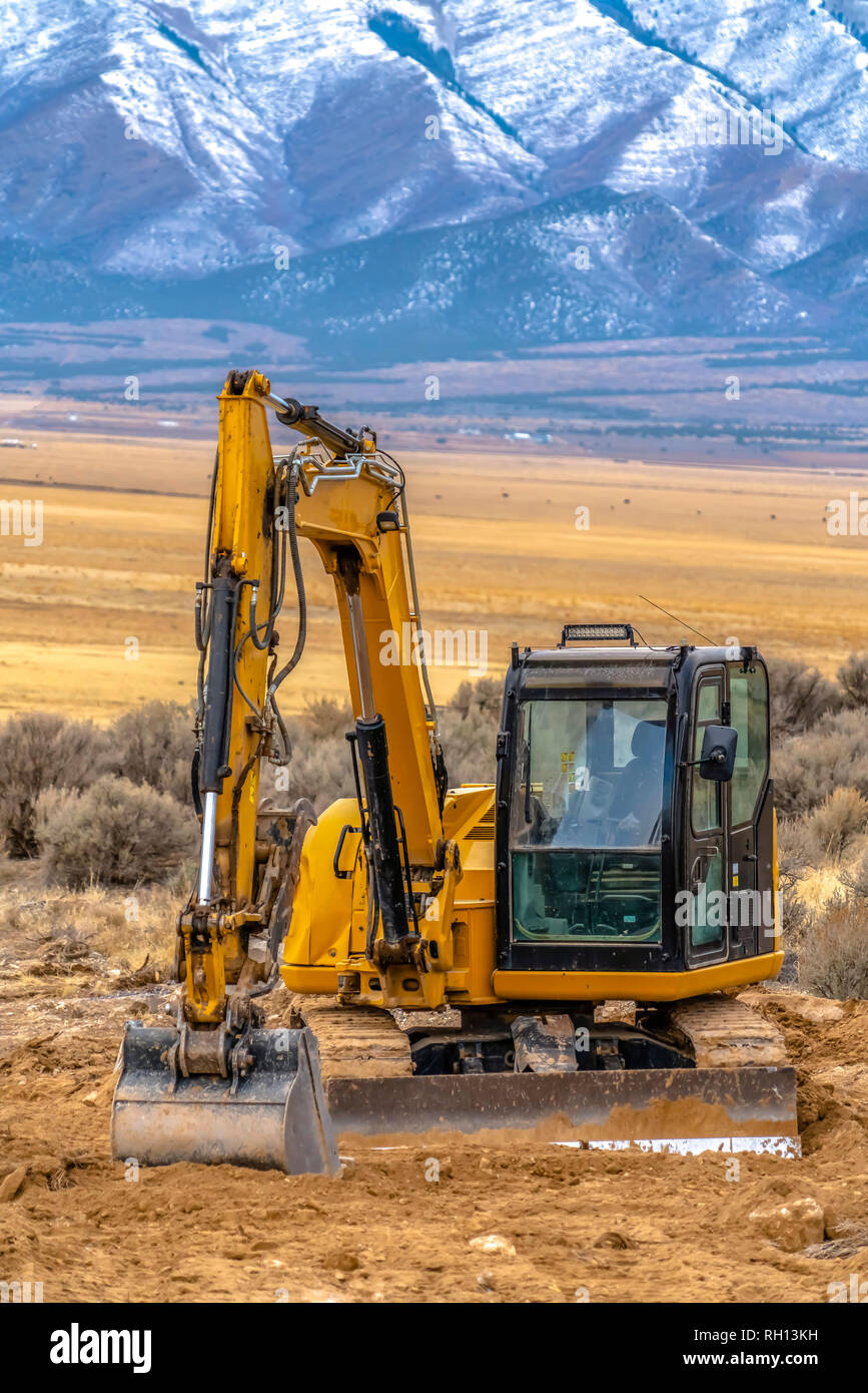 Excavator in Utah Valley with mountain background Stock Photo - Alamy