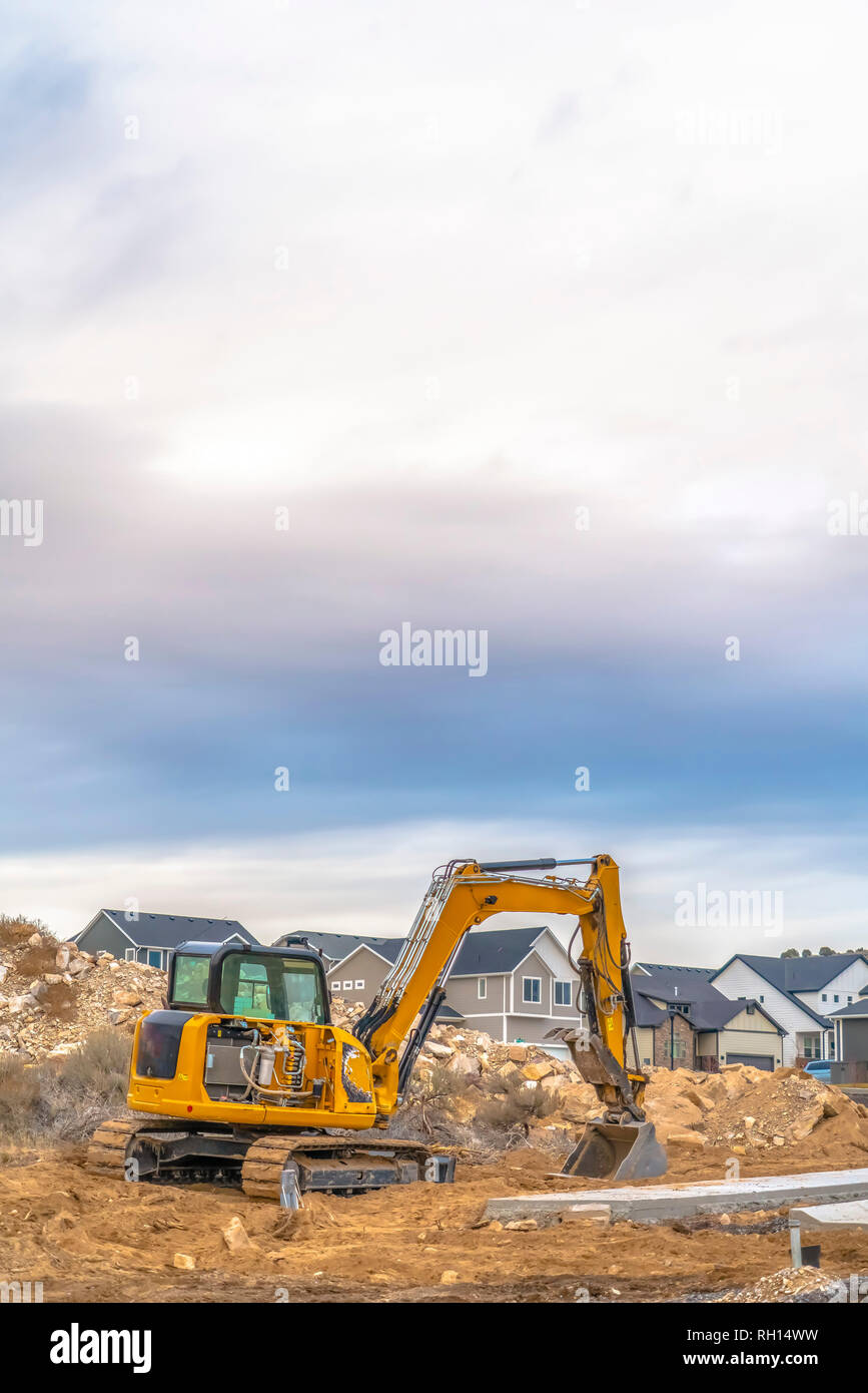 Excavator against homes and sky in Utah Valley Stock Photo - Alamy