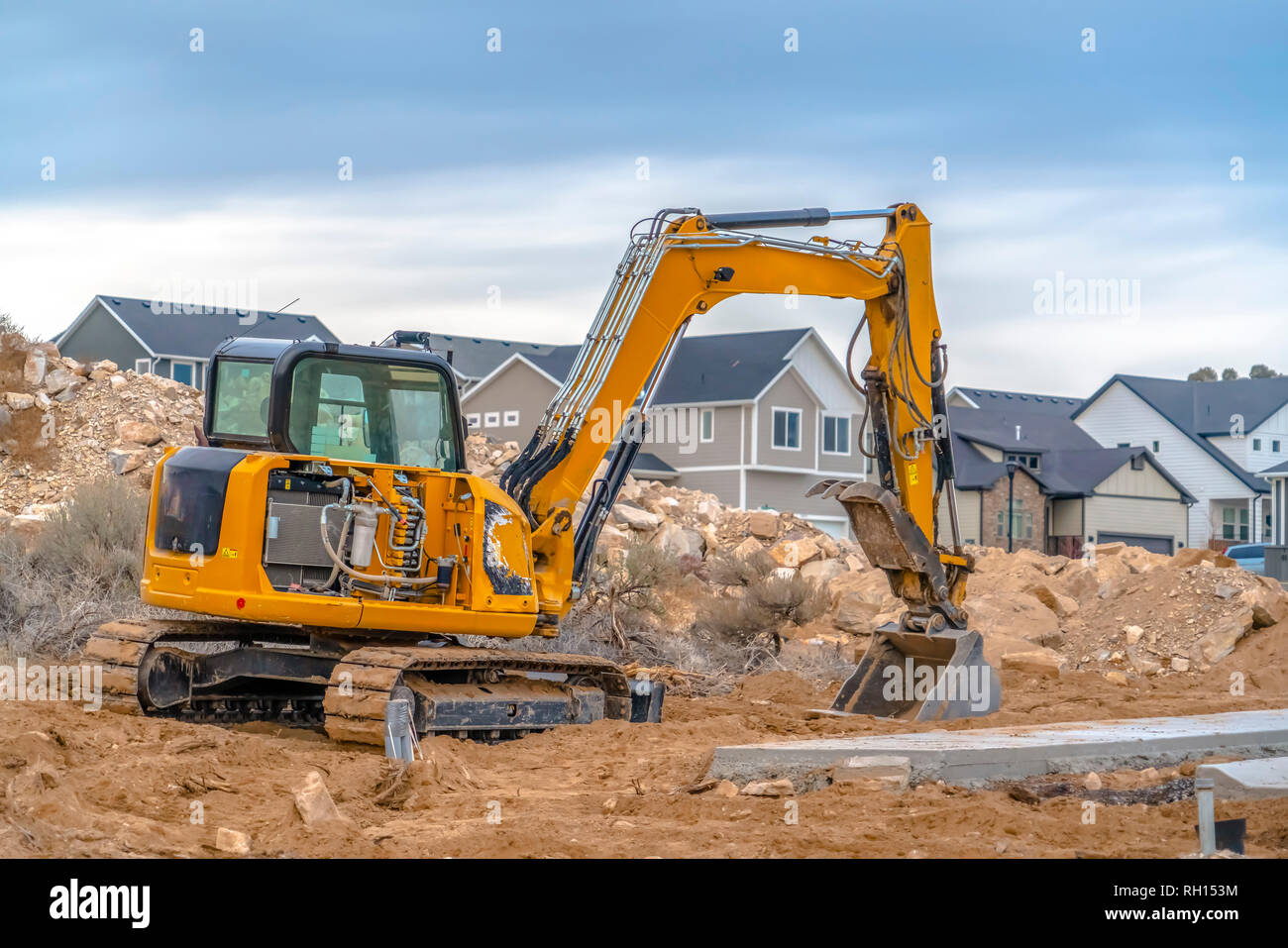 Excavator with Utah Valley homes in background Stock Photo - Alamy