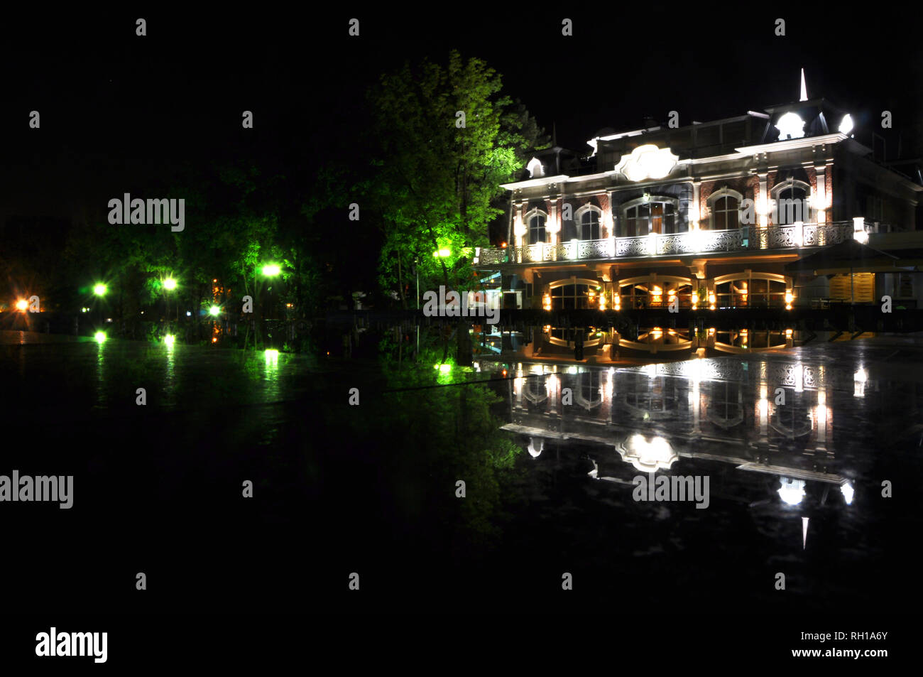 Night city. Building. fountain lights passing cars Stock Photo - Alamy