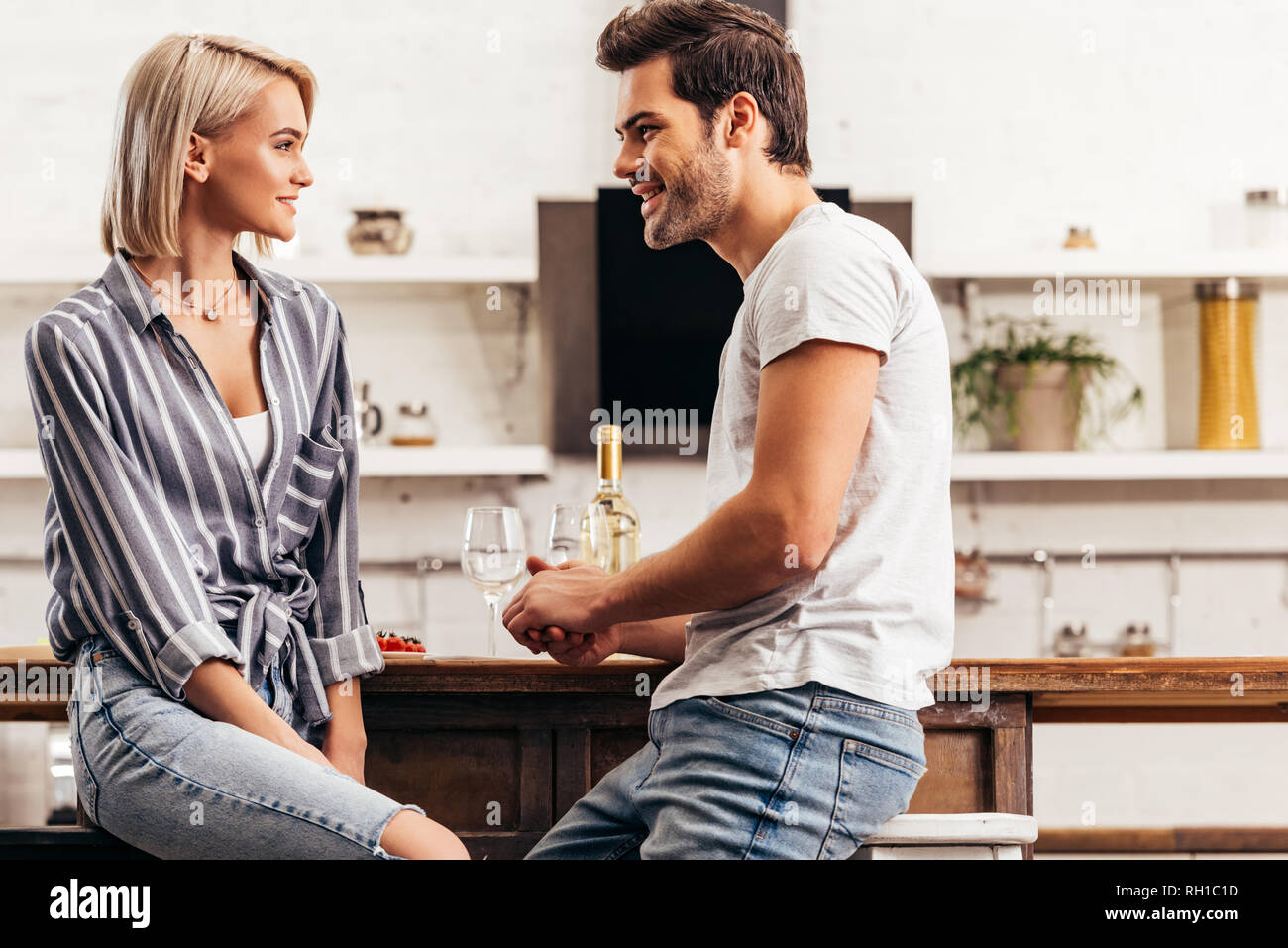 attractive girlfriend and handsome boyfriend sitting on chairs Stock