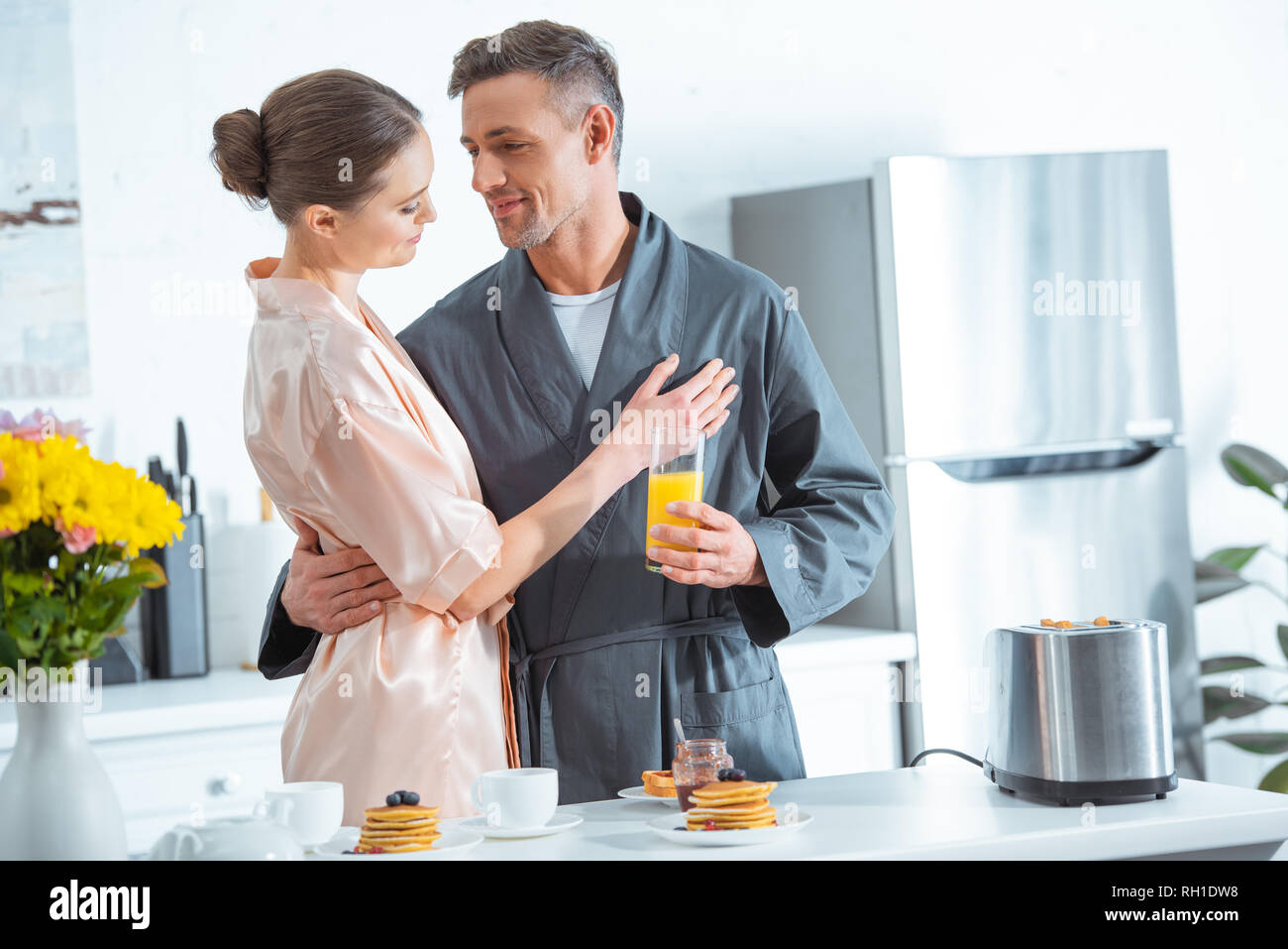 Breakfast In Robe beautiful woman in robe embracing man during breakfast in kitchen Stock ...