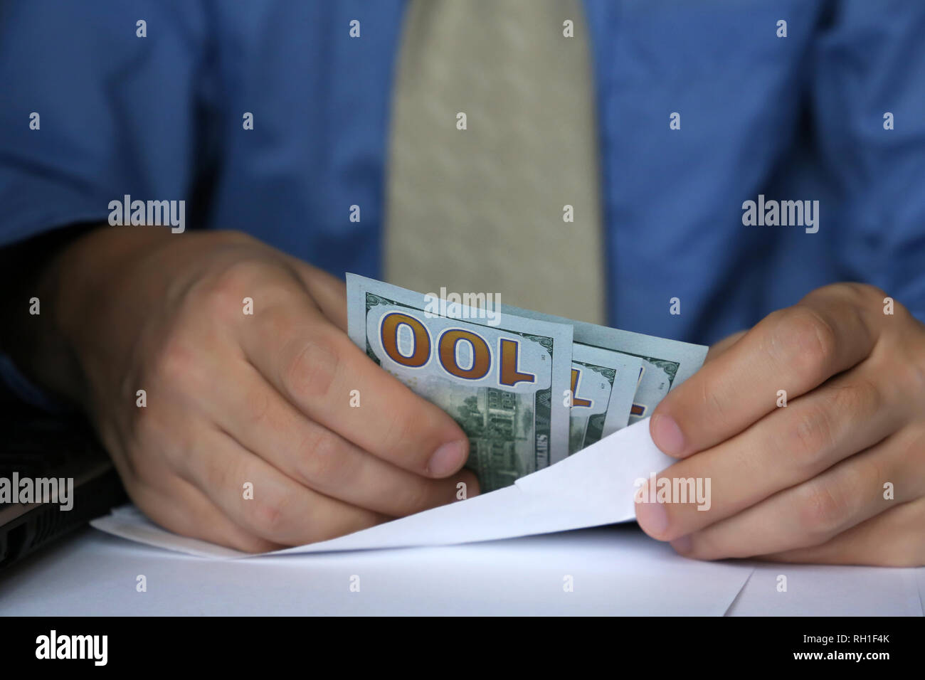 Envelope with dollars in male hands, close-up. Man in business clothes takes the money cash, concept of income, bribe, bonus, wages or savings Stock Photo