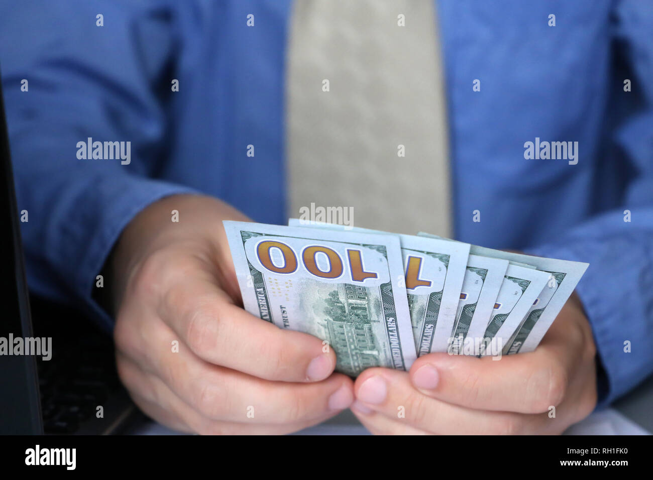 Man holding US dollars in hands, close-up. Clerk, official, manager or businessman counts the money sitting in office, concept of a salary, bribe Stock Photo