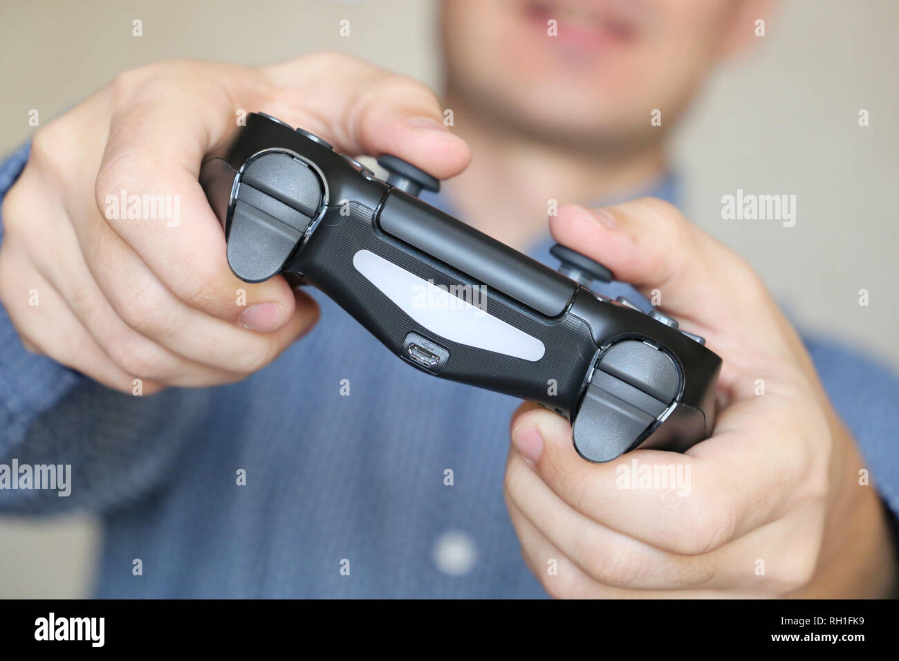 Joystick in male hands close-up, gamer playing video games with gamepad. Gaming addiction concept, home leisure Stock Photo