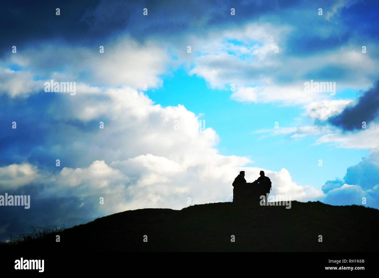 Two hikers inspecting a stone map on the top of St. Agnes Beacon, Cornwall, UK - John Gollop Stock Photo