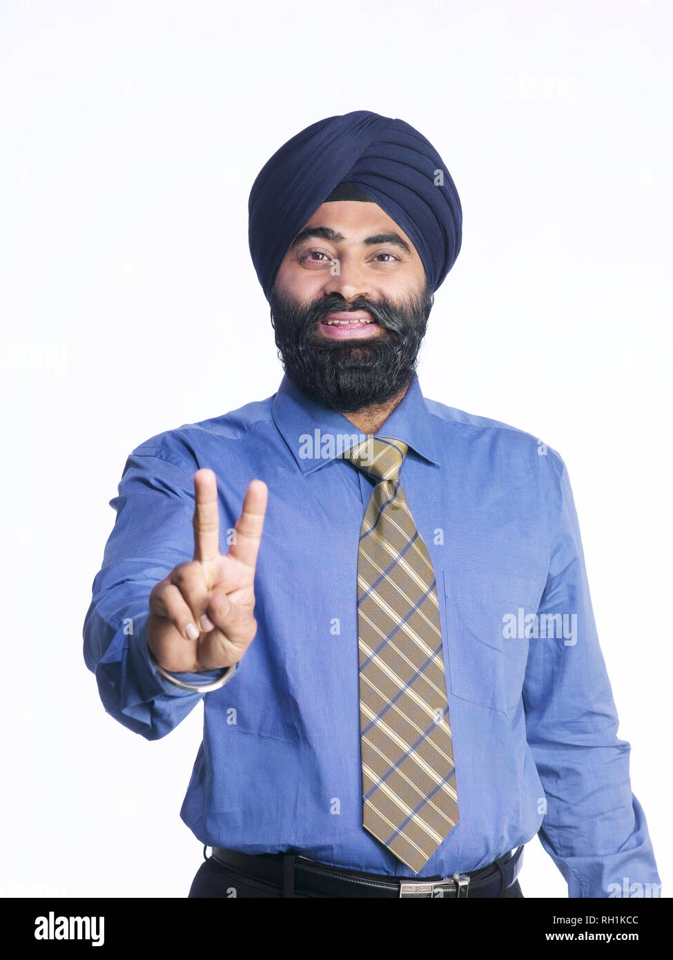 PORTRAIT OF A SIKH SARDAR MAN FLASHING A VICTORY SIGN Stock Photo