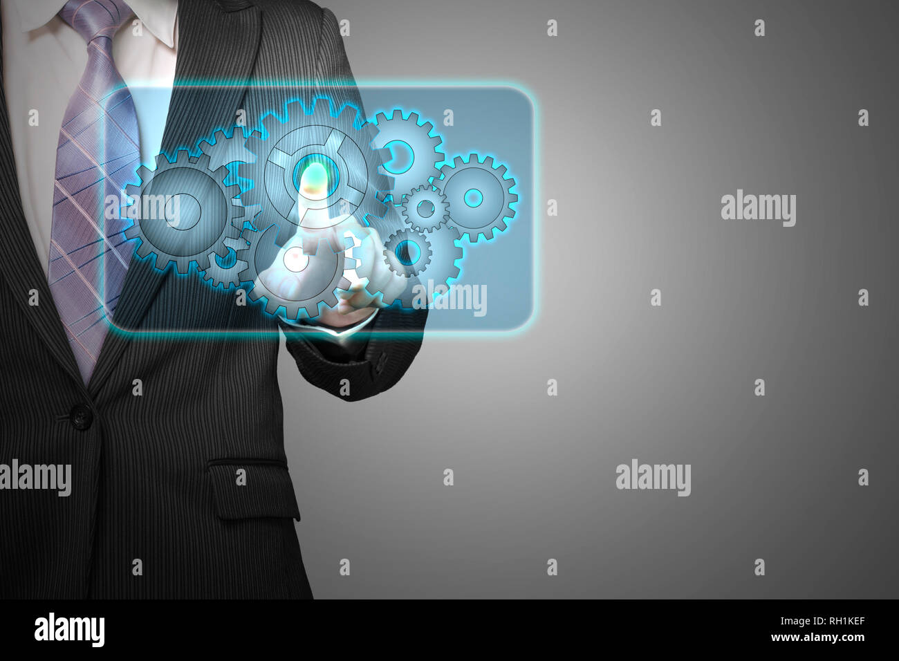 Businessman touch cloud shape filled with gears icon in space for launching service in gray background Stock Photo
