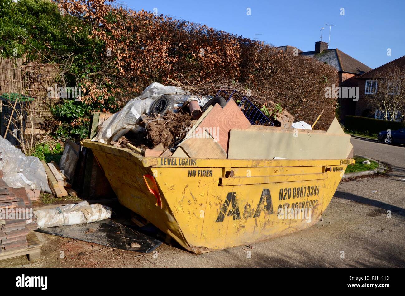 a full builders skip in london england Stock Photo Alamy