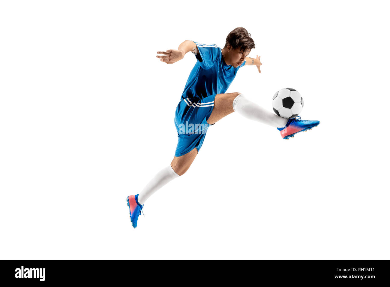 Young boy with soccer ball doing flying kick, isolated on white
