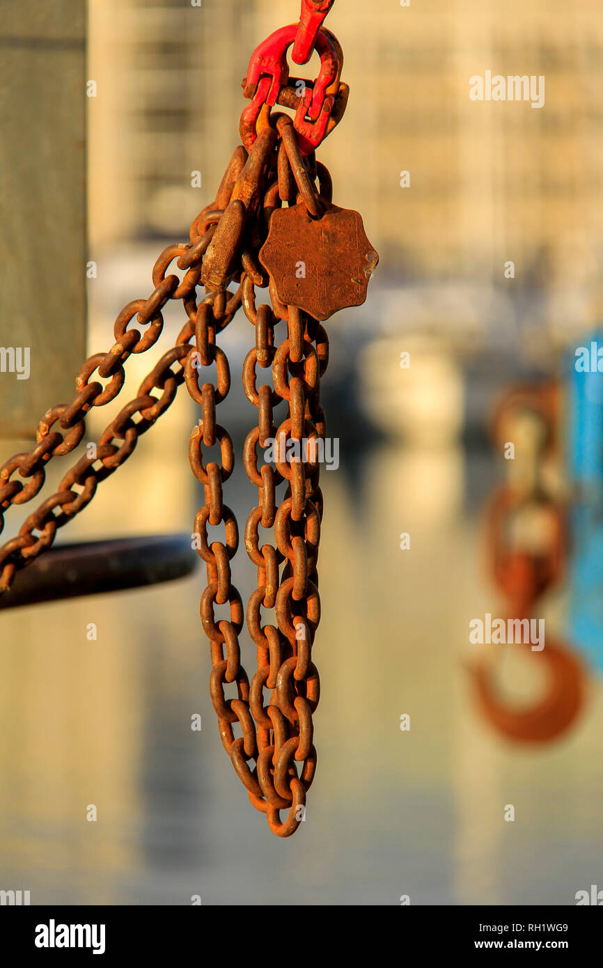 Crane shackles, hooks and rusty chain with blurry background Stock Photo