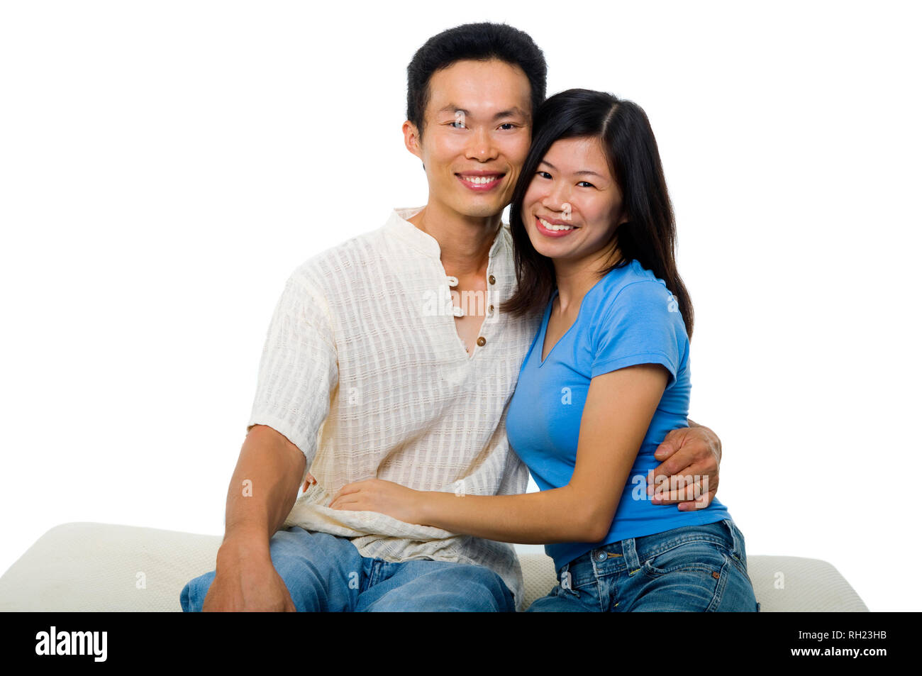 Young Asian couple sitting on sofa with smiling face, on white ...