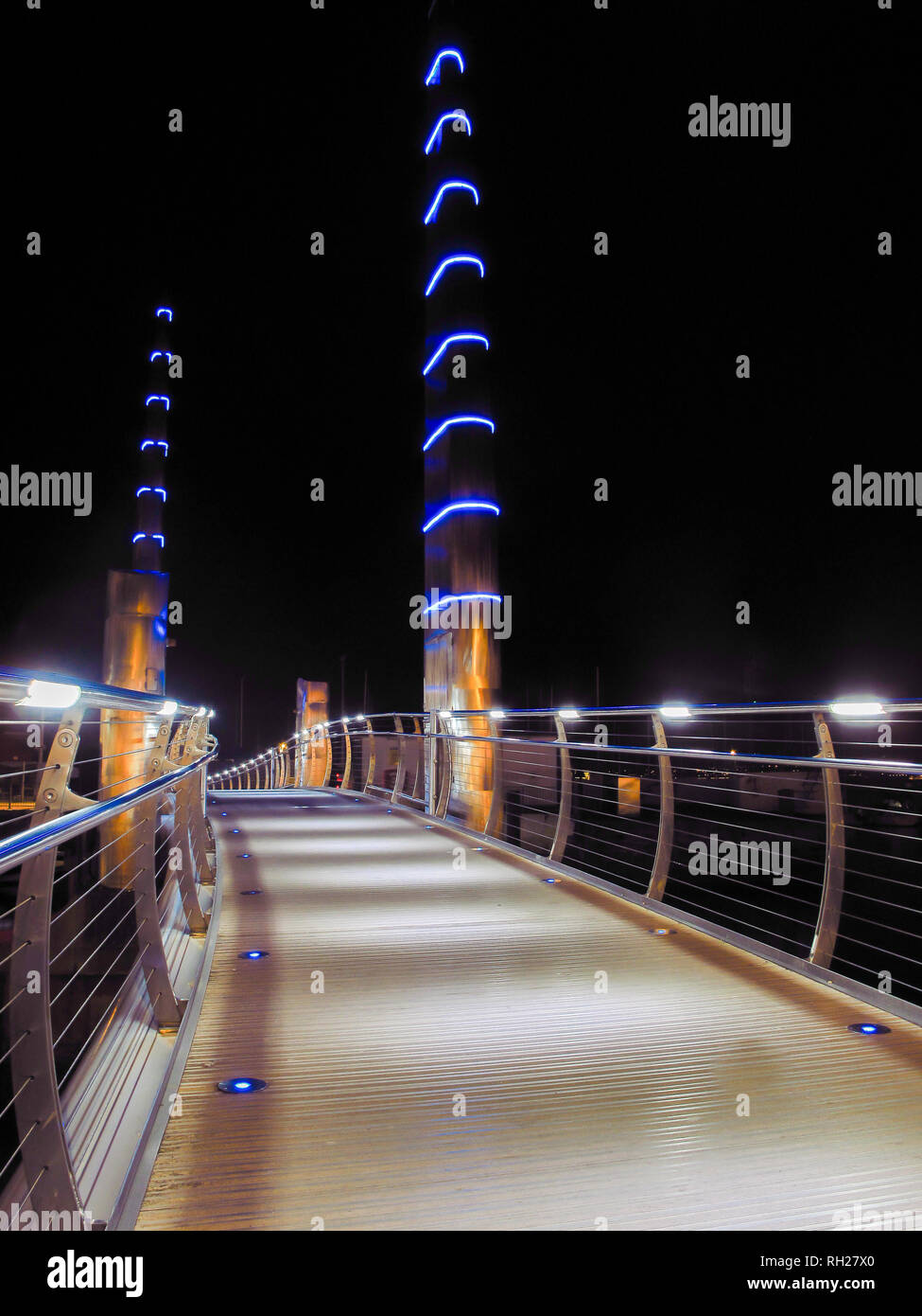 Walkway over Torquay Marina Harbour bridge with blue white and golden lights Stock Photo