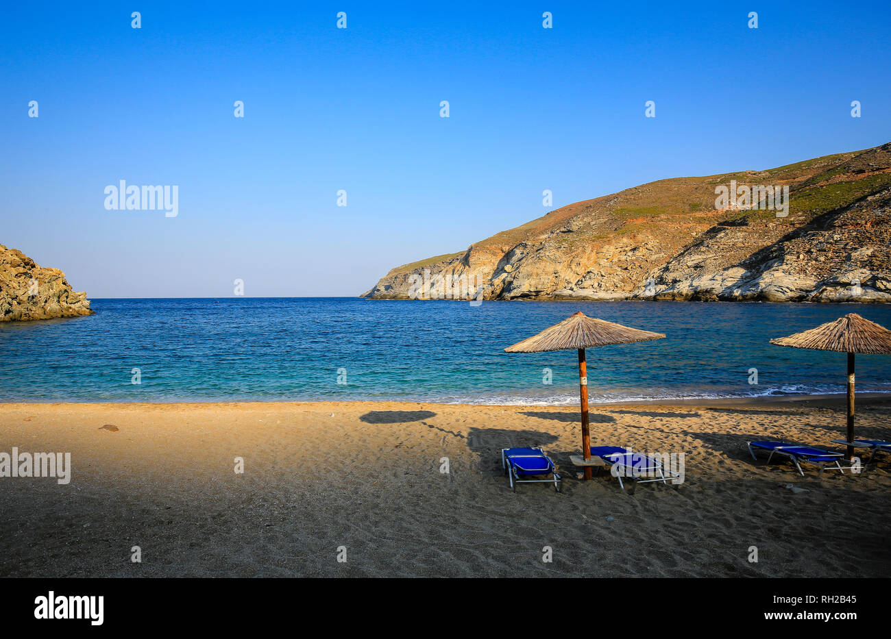 Island Andros, Cyclades, Greece - sunbeds and parasols on the beach Ormos Zorkou in the north of the island. Insel Andros, Kykladen, Griechenland - So Stock Photo