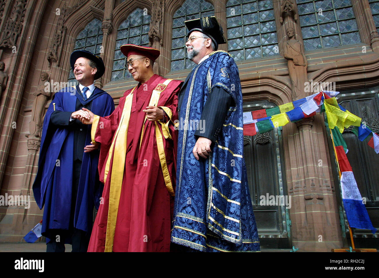 Wearing a specially designed robe for the occasion, His Holiness the Dalai Lama is welcomed by Lord David Alton (left, who leads JMU's Foundation for Citizenship) and Professor Michael Brown (vice chancellor of JMU) on the steps of Liverpool's Anglican Cathedral as he arrives to address the audience and receive an Honorary Fellowship from Liverpool John Moores University. This engagement was the first on the Dalai Lama's week-long visit to the UK, his first for five years. Stock Photo