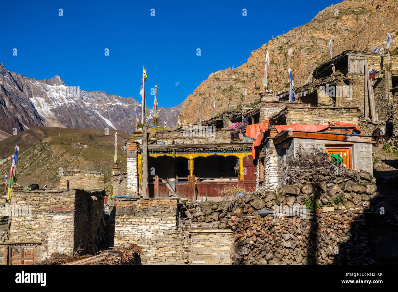 View on the traditional stone houses of the village, snow covered mountain range in the distance Stock Photo