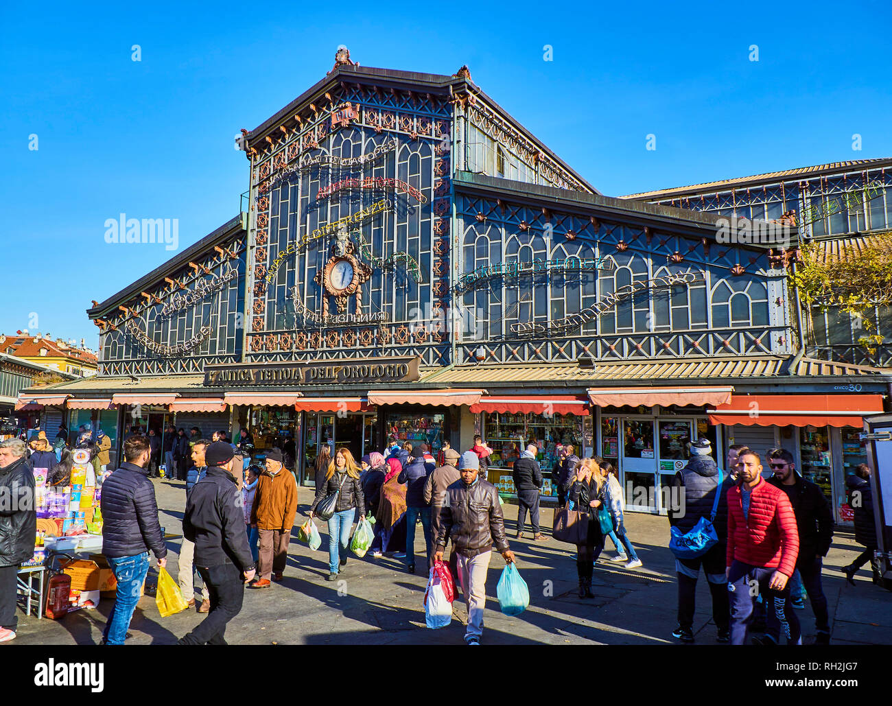 Citizens in front of the Antica Tettoia dell'Orologio building, the Fresh food part of Porta Palazzo market. Turin, Piedmont, Italy. Stock Photo