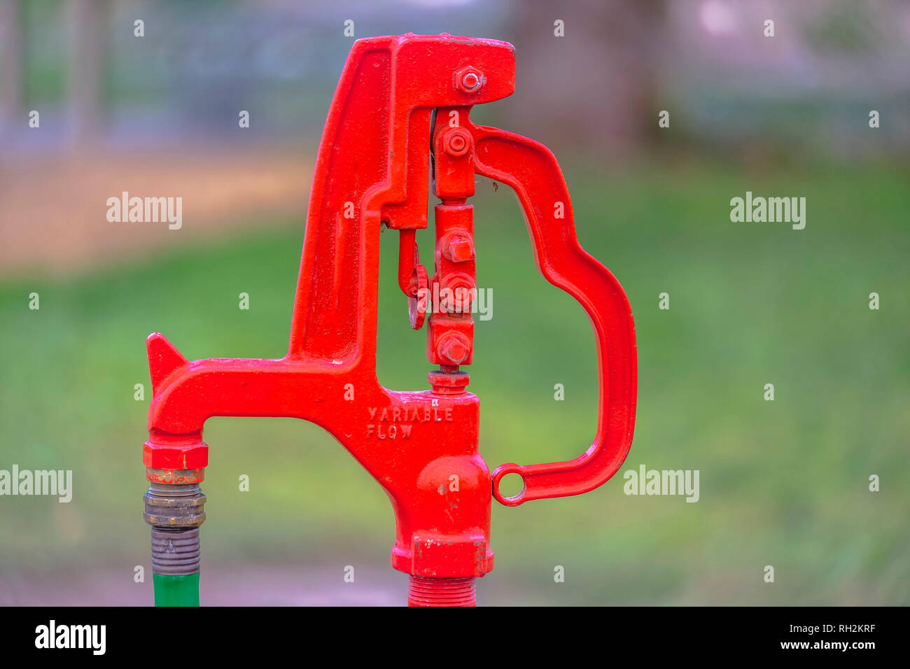 Red outdoor faucet with an attached green hose Stock Photo Alamy